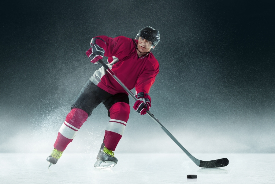 male-hockey-player-with-stick-ice-court-dark-wall